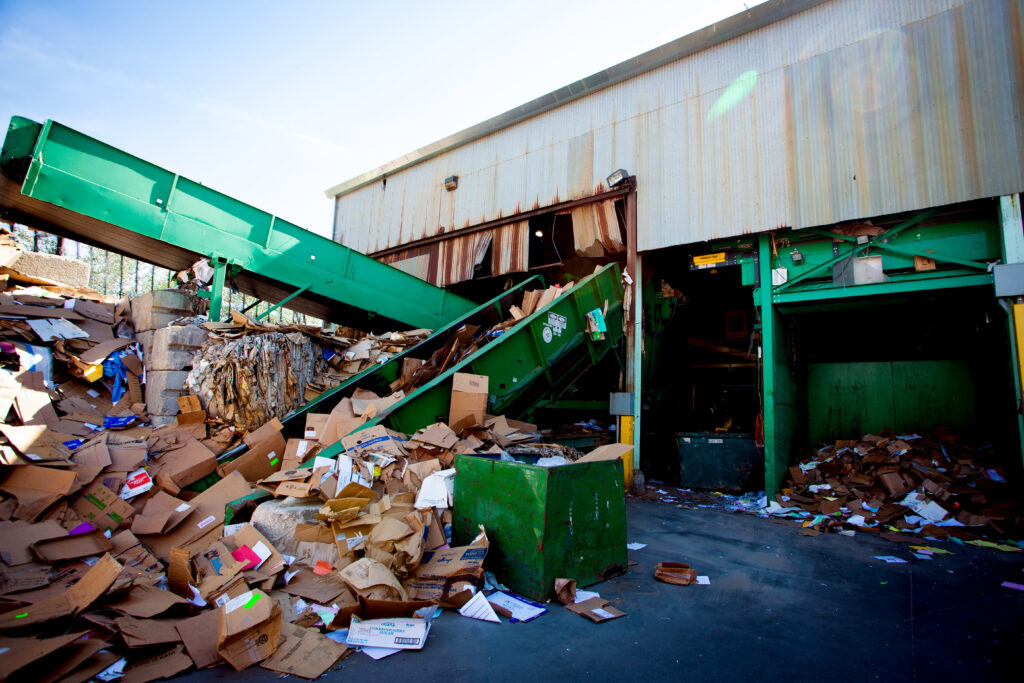 green recycling equipment outside of a recycling facility